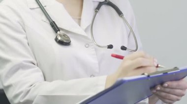 Doktor notlar yazıyor, kadın ellerini kapat Corona. Covid 19