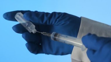 Doktor Corona 'ya iğne yapmak için bir şırınga hazırlıyor. Covid 19