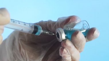 İlacı şırıngadan şırıngaya doldurmak mavi ilaç Corona. Covid 19