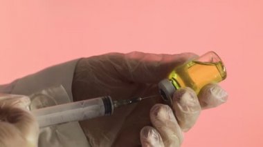 İlacı şırıngadan şırıngaya dolduruyorum. Pembe arka planda sarı bir ilaç Corona. Covid 19