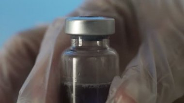 Mavi arka planda bir şırınga Corona. Covid 19