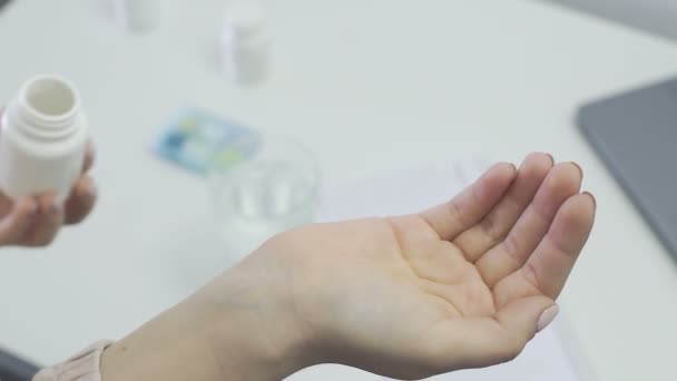 Kvinnan häller ut tabletterna ur flaskan på handen. Korona. Övergångsbestämmelser — Stockvideo