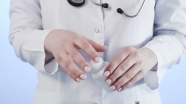 Doktor, mavi arka plandaki Corona 'nın üzerine beyaz bir hap döker. Covid 19