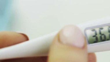 Kadınların medikal dijital termometresi Corona 'nın elinde. Covid 19