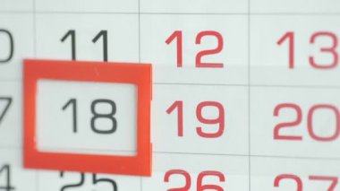 Ofisteki kadınlar duvar takvimindeki tarihi değiştirirler. Değişiklikler 18 'den 19' a
