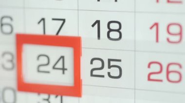 Ofisteki kadınlar duvar takvimindeki tarihi değiştirirler. Değişiklikler 24 ile 25 arasında