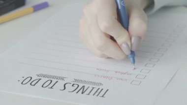 Not defterinde yapılacaklar listesini dolduran iş kadını
