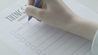 Not defterinde yapılacaklar listesini dolduran genç kız.