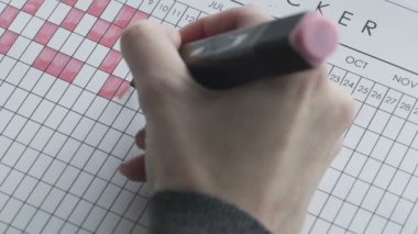 Kırmızı keçeli kalemle takvimdeki günler işaretleniyor