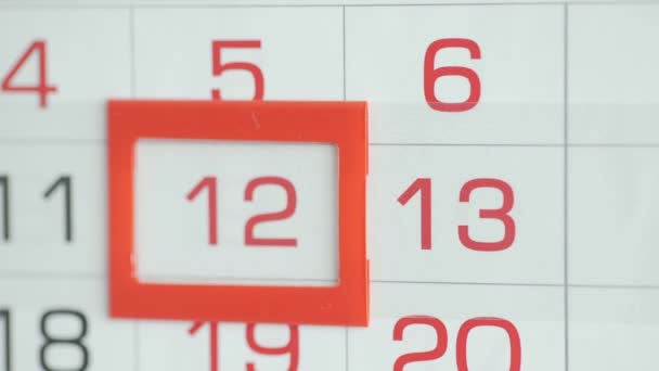 Womans hand in office changes date at wall calendar. Changes 12 to 13 — Stock Video