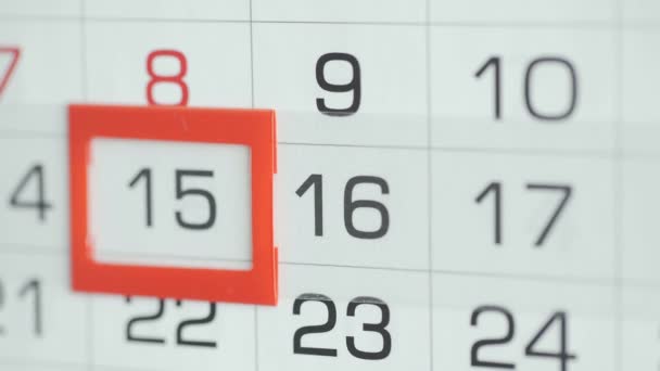 Las mujeres de la mano en la oficina cambia la fecha en el calendario de pared. Cambios 15 a 16 — Vídeo de stock