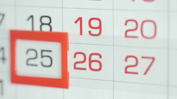 Womans hand in office changes date at wall calendar. Changes 25 to 26 — Stock Video