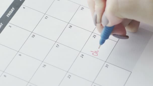 Womans mão escrevendo com caneta vermelha na palavra calendário Natal — Vídeo de Stock