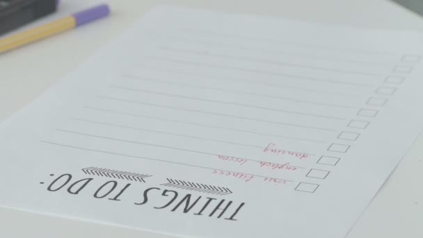 Estudiante llenando lista de tareas pendientes en notebook — Vídeos de Stock