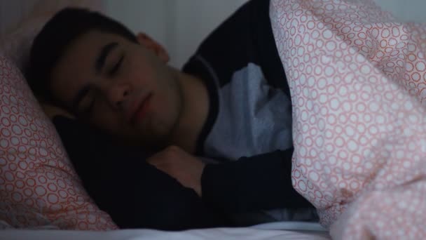 Mannen tittar sin smarta telefon i sängen på natten närbild — Stockvideo
