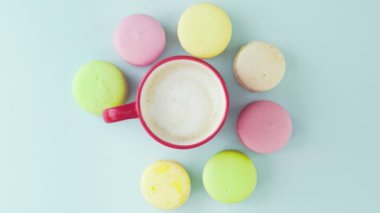 Makaronlar ya da pastel mavi yüzey üzerinde kırmızı bardakta kahve ile makarna..