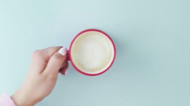 Makaronlar ya da pastel mavi yüzey üzerinde kırmızı bardakta kahve ile makarna..