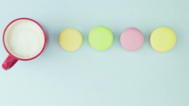 Makaronlar ya da pastel mavi yüzey üzerinde kırmızı bardakta kahve ile makarna..