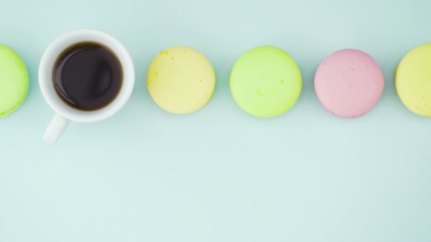 Makronen oder Macaron auf pastellblauer Oberfläche mit Espresso in weißer Tasse. — Stockvideo