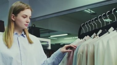 Butikte kıyafet seçen genç ve güzel bir kız..