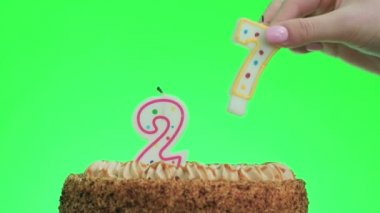 Lezzetli bir pastaya 27 numaralı doğum günü mumunu koyuyorum, yeşil ekran 27.