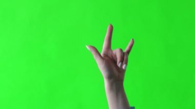 Yeşil ekranda parmakları olan boynuzların işareti. Heavy metal rock 'ın simgesi. Bir elin parmaklarıyla jestler..