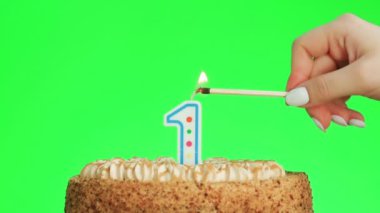 Bir numaralı doğum günü mumunu yakıyorum. Lezzetli bir pasta, yeşil ekran 1.
