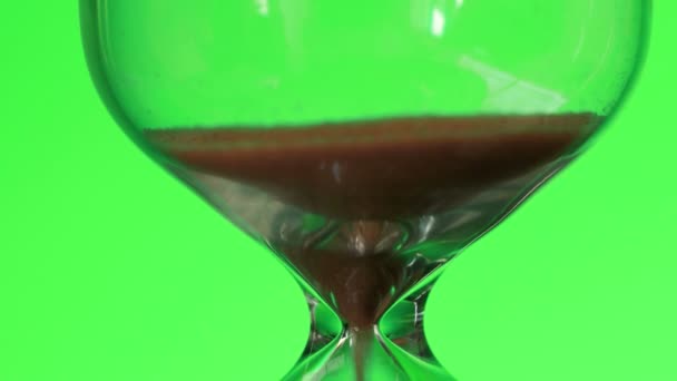 Hourglass on green background. Sand is pouring from one part to another. Time and transience concept. — Stock Video