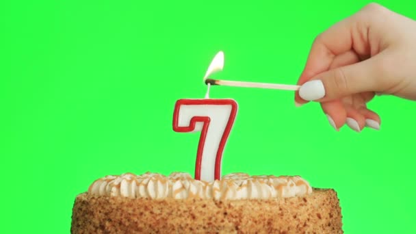 Éclairage d'une bougie d'anniversaire numéro sept sur un délicieux gâteau, écran vert 7 — Video