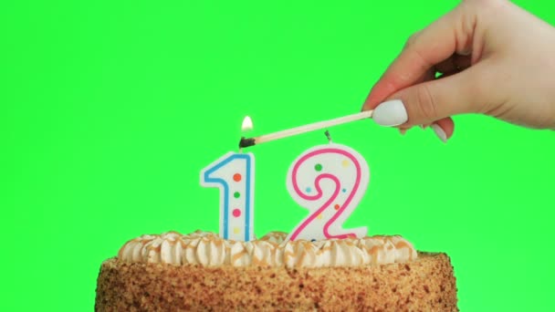 Зажигание свечи дня рождения номер двенадцать на вкусном торте, зеленый экран 12 — стоковое видео
