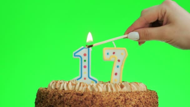 Anzünden einer Zahl siebzehn Geburtstagskerze auf einem leckeren Kuchen, grüne Leinwand 17 — Stockvideo