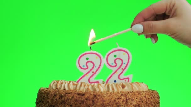 Éclairage d'une bougie numéro vingt-deux d'anniversaire sur un délicieux gâteau, écran vert 22 — Video