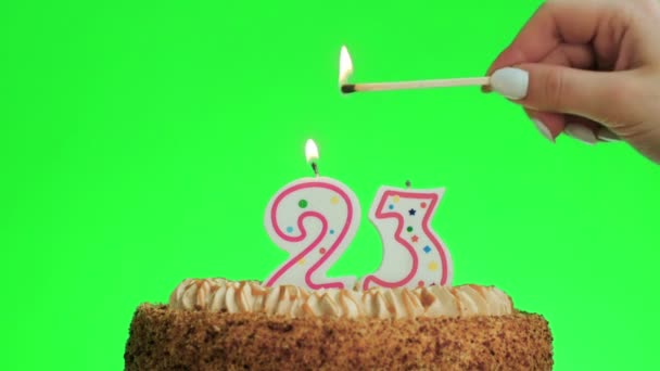 Éclairage d'une bougie numéro vingt-trois d'anniversaire sur un délicieux gâteau, écran vert 23 — Video