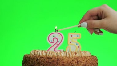 Lezzetli bir pastada 25 numaralı doğum günü mumunu yakıyorum, yeşil ekran 25.