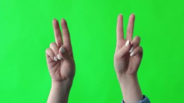 Yeşil ekran stüdyosu. İki el barışın göstergesi.