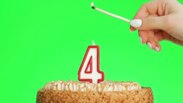 Allumage d'une bougie d'anniversaire numéro quatre sur un délicieux gâteau, écran vert 4 — Video