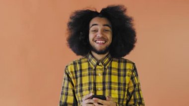 Genç mutlu Afrikalı işadamı telefonu kullanıyor ve Orange hakkında iyi haberler alıyor. Duyguların kavramı