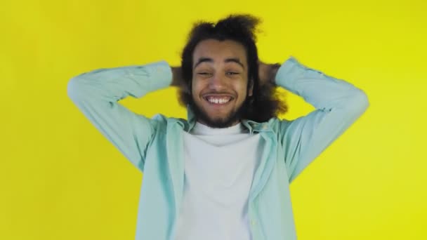 Besorgter Afroamerikaner lacht, hält die Hände vors Gesicht und feiert den Erfolg auf gelbem Hintergrund. — Stockvideo