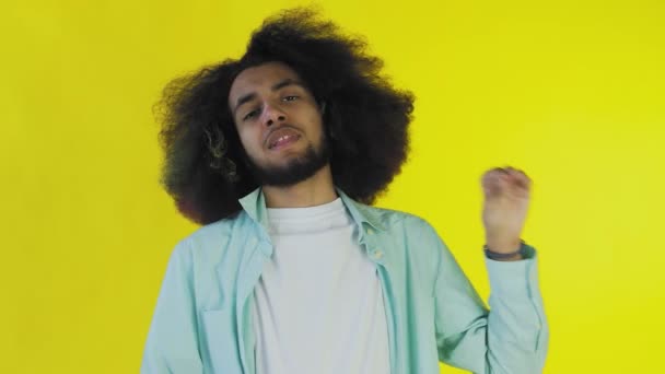 A fiatal afro-amerikai férfi csendet vagy bla bla gesztust mutat a sárga háttérben. Az érzelmek fogalma — Stock videók