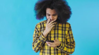 Genç üzgün Afro-Amerikalı adam telefonu kullanıyor ve mavi arka plandan kötü haberler alıyor. Duyguların kavramı