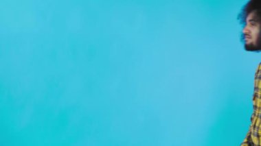 Çerçevede yürüyen Afro-Amerikan bir adam, Mavi arka planda telefonundan yeni bir mesaj aldı. Duyguların kavramı