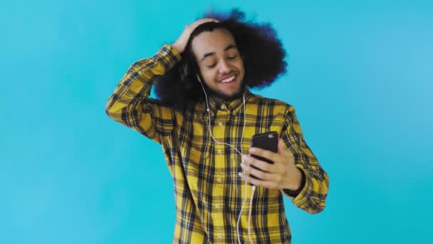 年轻的非洲裔美国人视频呼叫与蓝色背景的电话。情绪的概念 — 图库视频影像