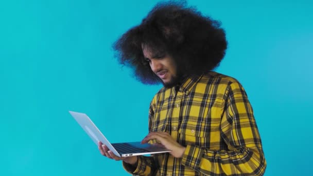 Uomo afroamericano che digita al computer portatile. No, scuotendo la testa. Sullo sfondo blu. Concetto di emozioni — Video Stock