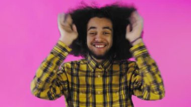 Endişeli Afro-Amerikalı Adam gülüyor, ellerini yüzüne dikiyor ve Mor Arkaplanda Başarı Kutlaması.
