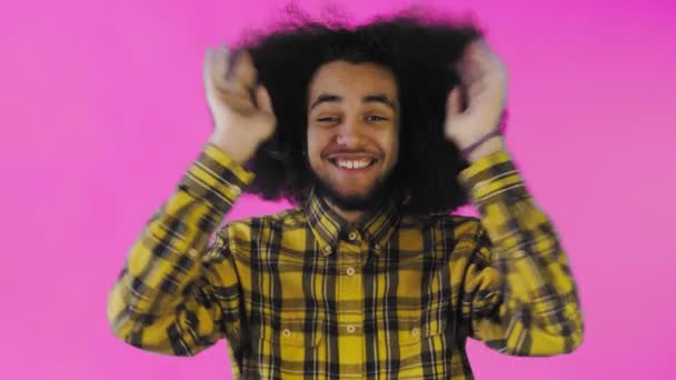 Ustaraný Afro-americký muž se směje, drží jí ruce na tváři a slaví úspěch na fialovém pozadí. — Stock video