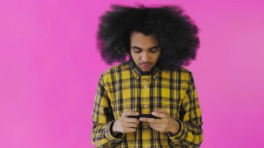 Afro-Amerikalı adam mor arka planda Smartphone 'da oyun oynuyor. Duyguların kavramı