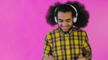 Mor arka planda kulaklıklarıyla müzik dinleyen Afro-Amerikalı olumlu bir adam. Duyguların kavramı