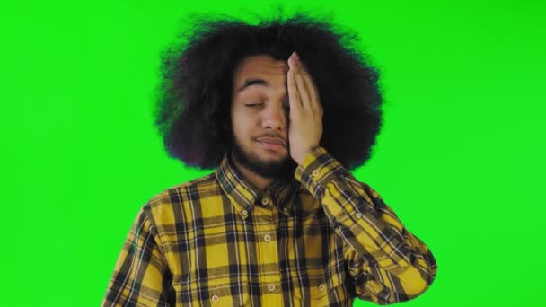 Pria afro amerika yang kecewa melakukan gerakan facepalm terhadap layar hijau atau latar belakang kunci kroma. Konsep emosi — Stok Video
