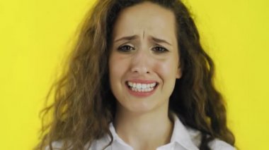 Hayal kırıklığına uğramış kadın sarı arka planlı stüdyoda 