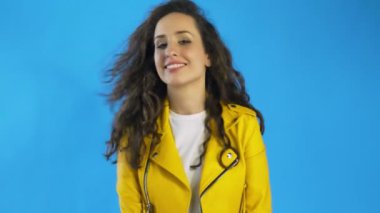 Güzel kadın kameraya bakıyor, göz kırpıyor, flört ediyor ve gülümsüyor..